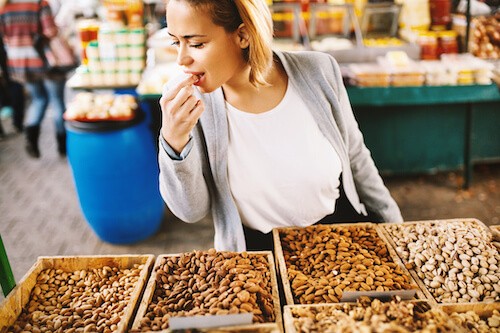 woman eats nuts rich in vitamin e to prevent varicose veins